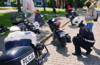 Obraz przedstawia policjanta kontrolującego motocykle