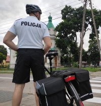 Obraz przedstawia policjanta w patrolu rowerowym