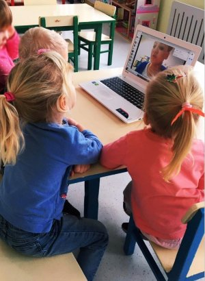 obraz przedstawia dzieci patrzące na monitor laptopa, w tle zabawki