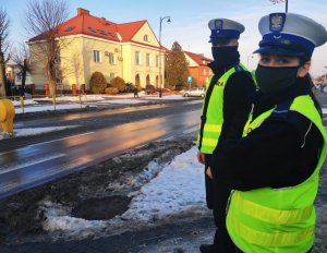 Obraz przedstawia policjantów przed przejściem dla pieszych