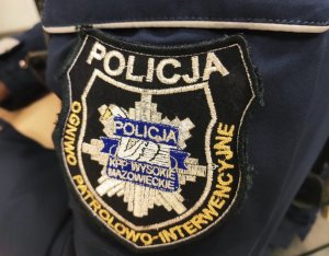 obraz przedstawia ramię policjanta w mundurze z naszywką z napisem Policja Ogniwo patrolowo-interwencyjne KPP Wysokie Mazowieckie