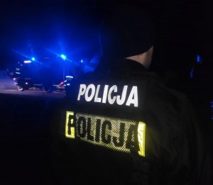 obraz przedstawia policjanta w kamizelce odblaskowej w porze nocnej