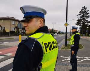 obraz przedstawia policjantów ruchu drogowego obserwujących przejście dla pieszych