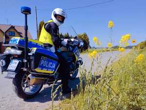 obraz przedstawia policjanta siedzącego na  motocyklu