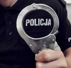 obraz przedstawia dłoń policjanta trzymającego kajdanki