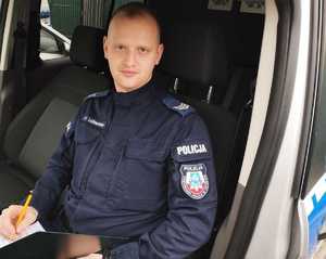 obraz przedstawia policjanta w radiowozie