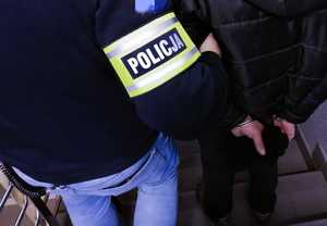 obraz przedstawia policjanta z zatrzymanym mężczyzną